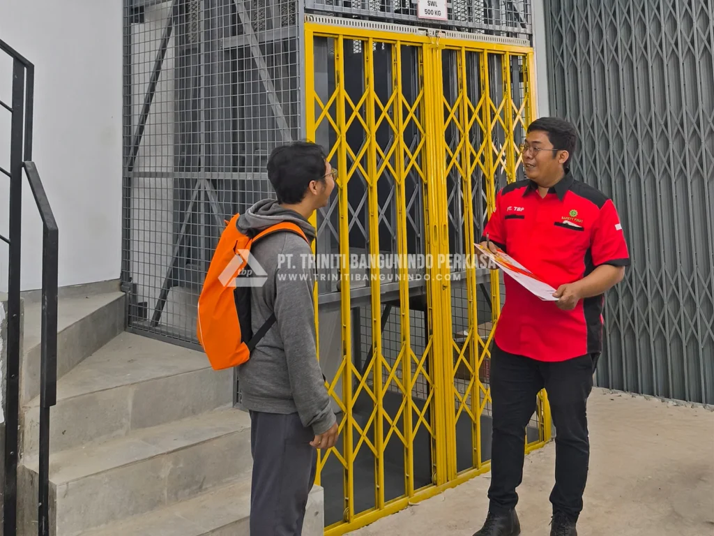 Sales Engineer Triniti berdiskusi dengan customer di area instalasi Lift Barang